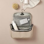 Trousse de toilette de voyage personnalisable, pratique et élégante, pour un cadeau d'entreprise ou un goodies publicitaire, avec crochet et compartiments.